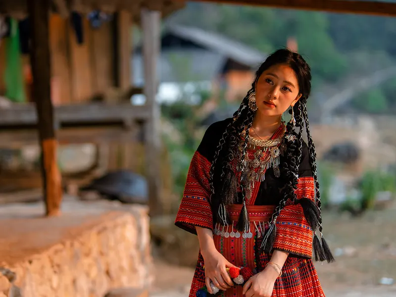 Jeune femme Hmong en tenue traditionnelle dans un village de Ha Giang