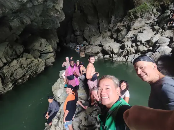Groupe Infinity devant une grotte au bord de la rivière, boucle de Ha Giang